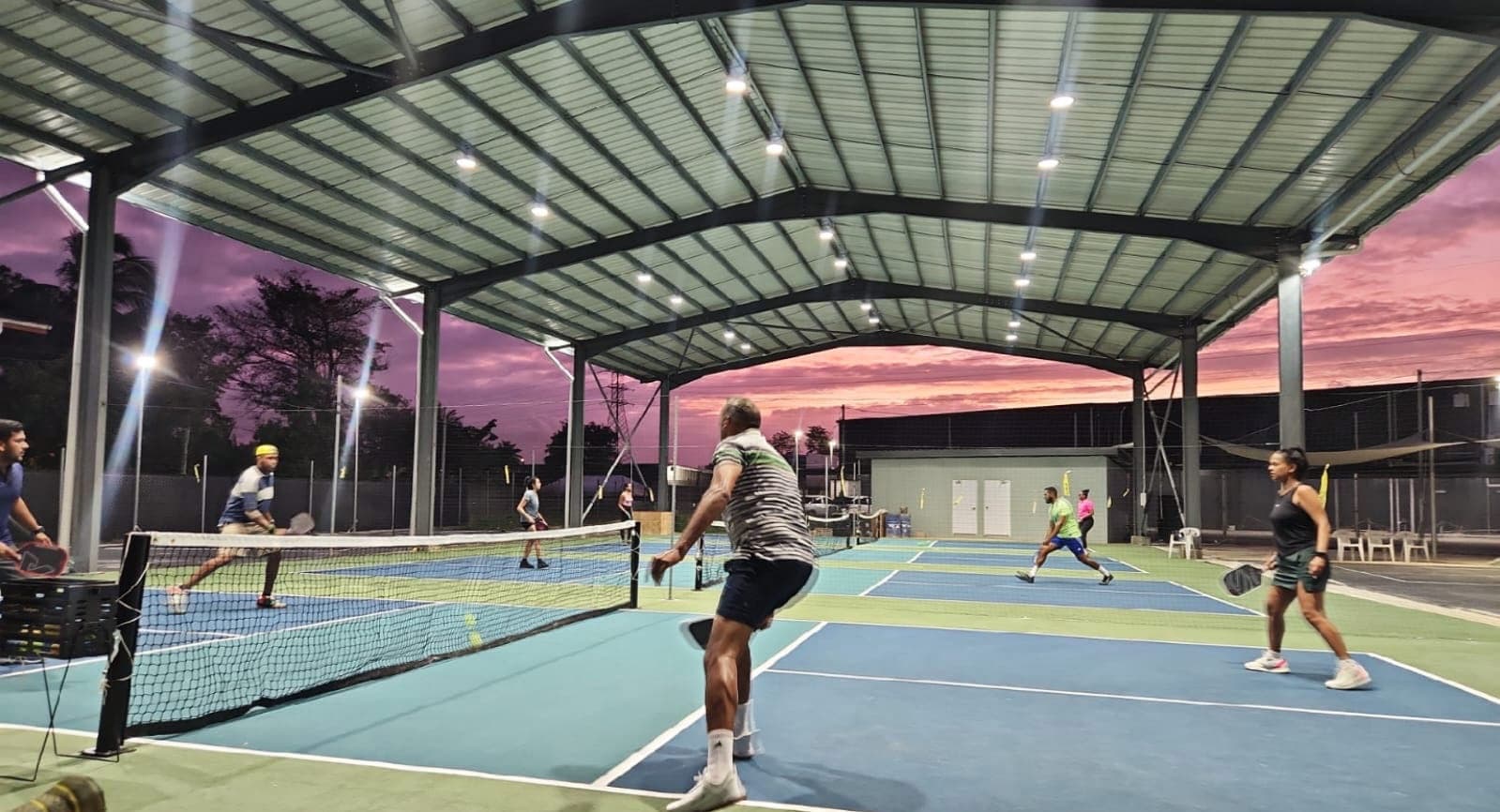 Friends playing a doubles match together at sunset